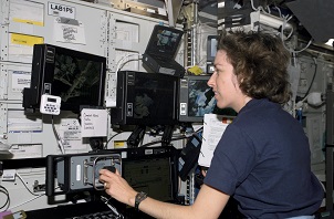 Figura 6: La astronauta Ellen Ochoa en los controles del brazo robótico del transbordador.