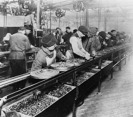 Figure 1: Workers on the first moving assembly line put together magnetos and flywheels for 1913 Ford automobiles.